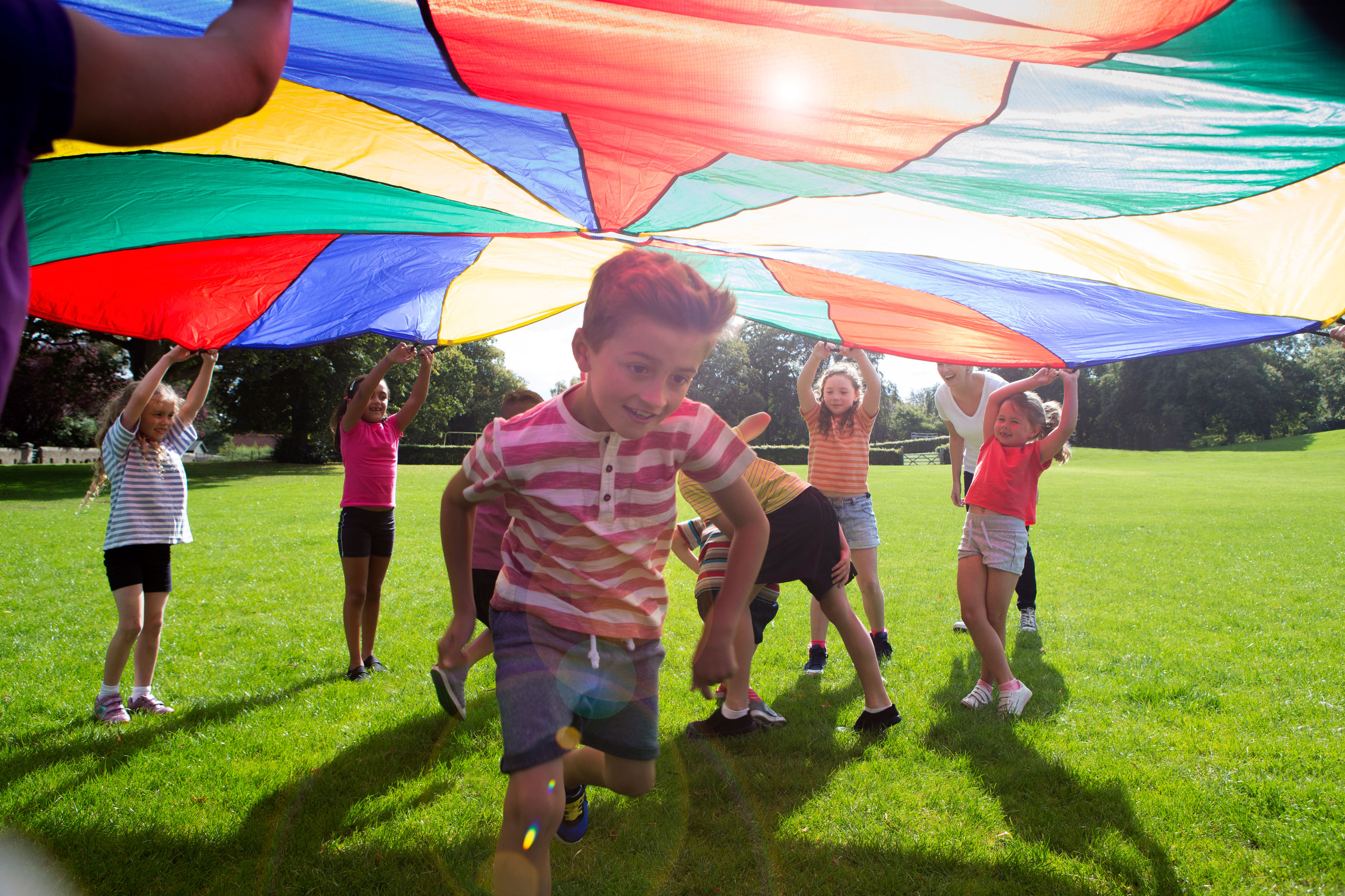 kids playing under colored tarp