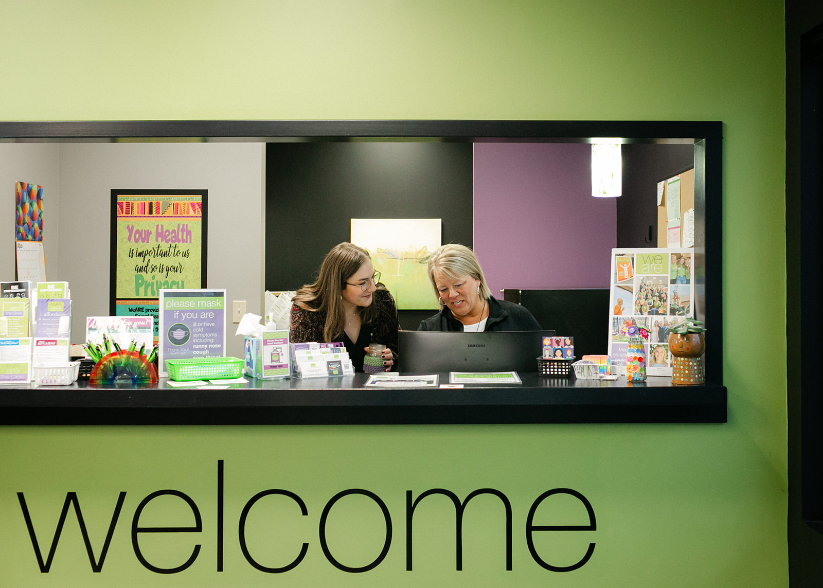 Photo of the welcome desk with happy providers at WeARE - The Clinic.