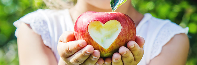 Image illustrating a child's hands holding an apple