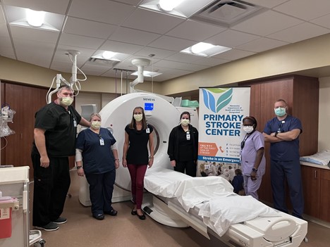 healthcare workers standing next to an MRI machine