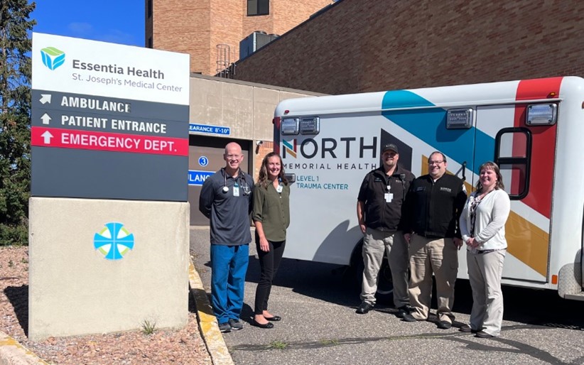 healthcare workers standing next to an ambulance