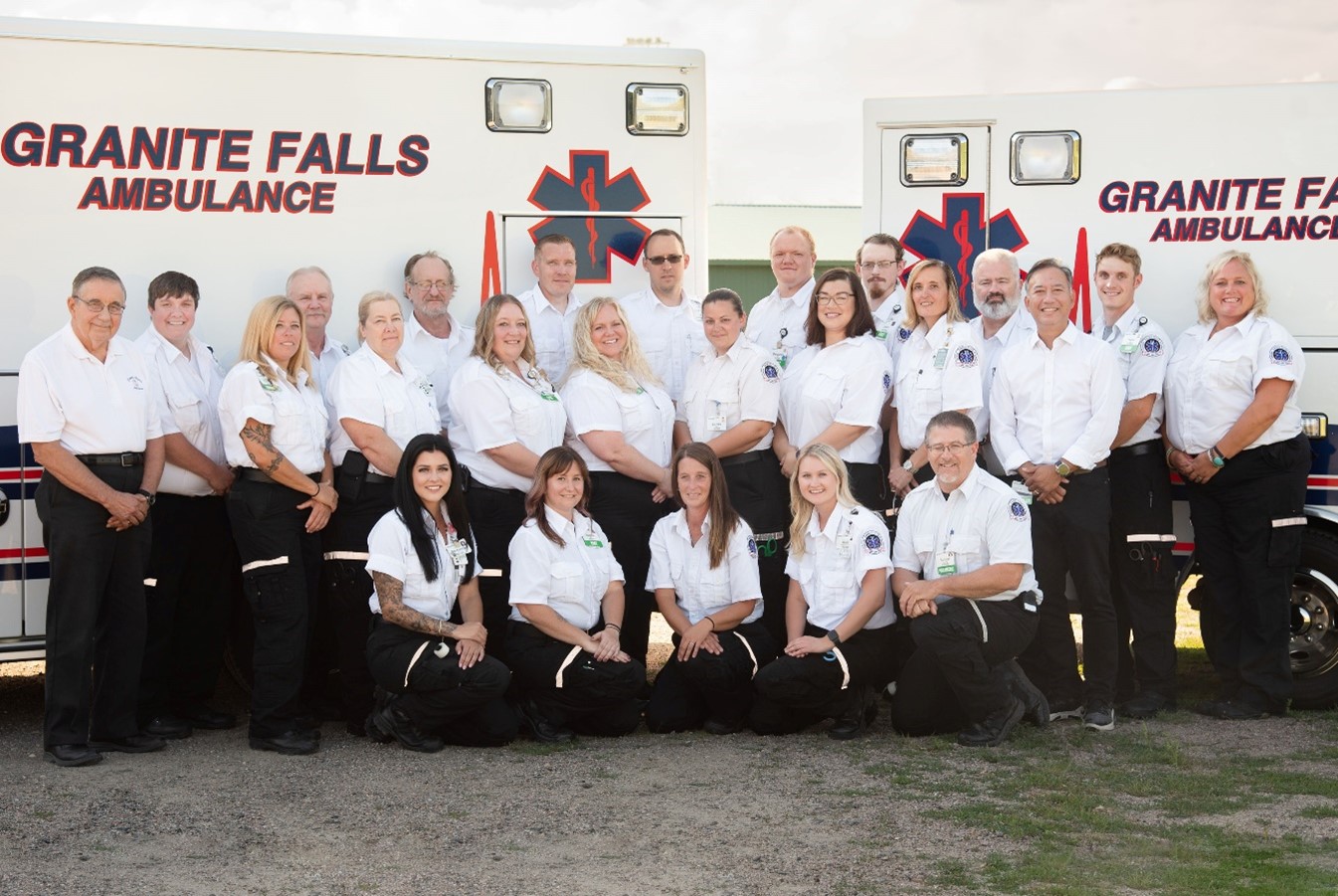 healthcare workers standing next to two ambulances