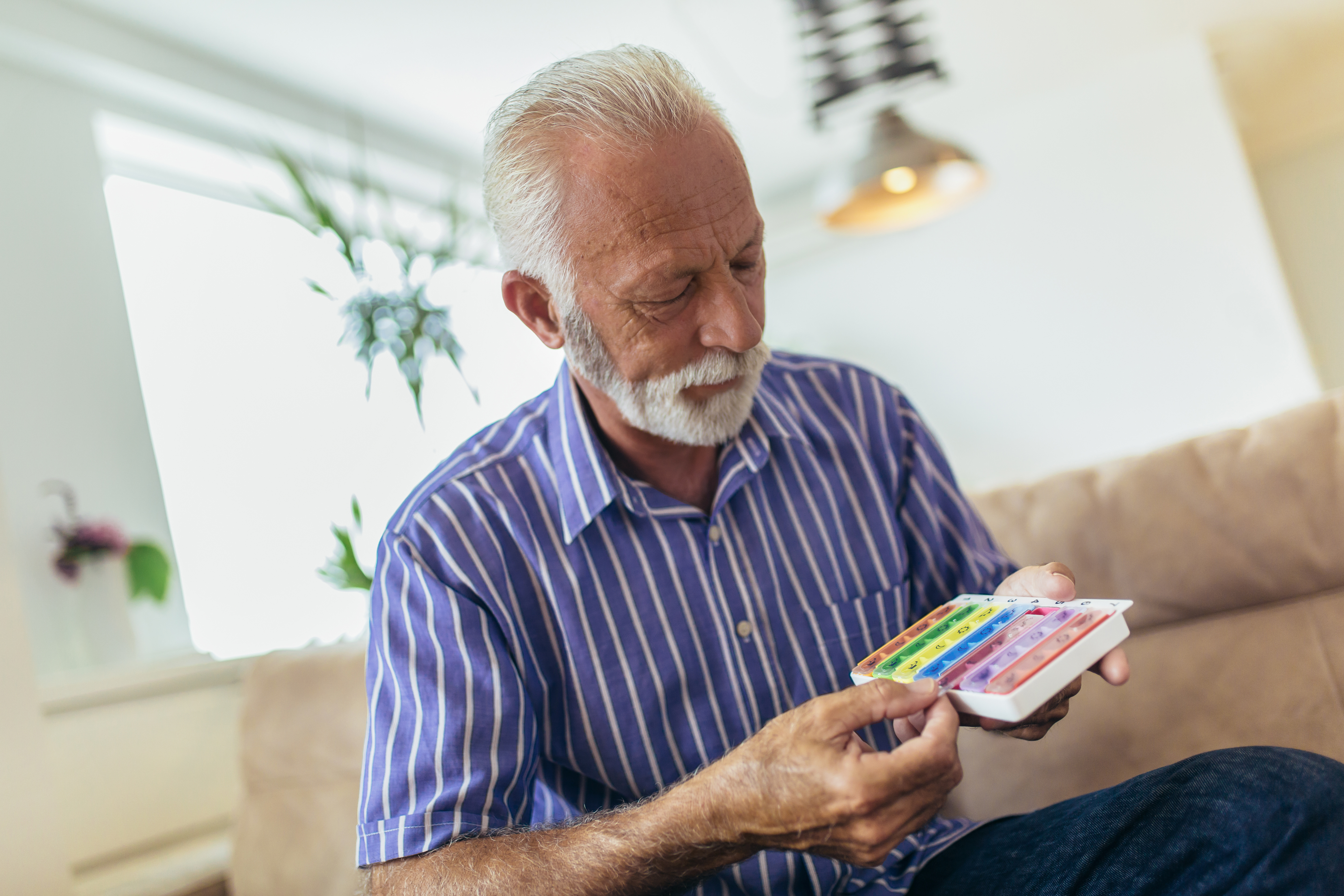 man looking at pill box