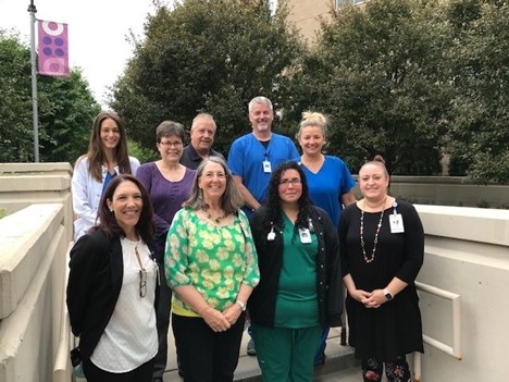 nine healthcare workers standing in two rows outside