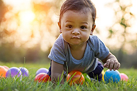 child crawling through the grass