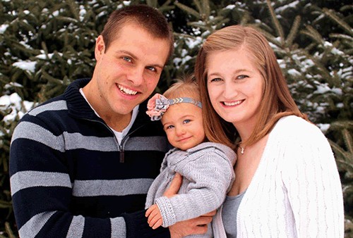 Dad holding baby and mom leaning in - all smiling